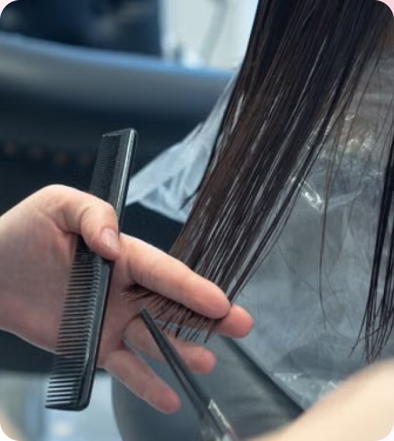 A stylist combing through a client's wet hair