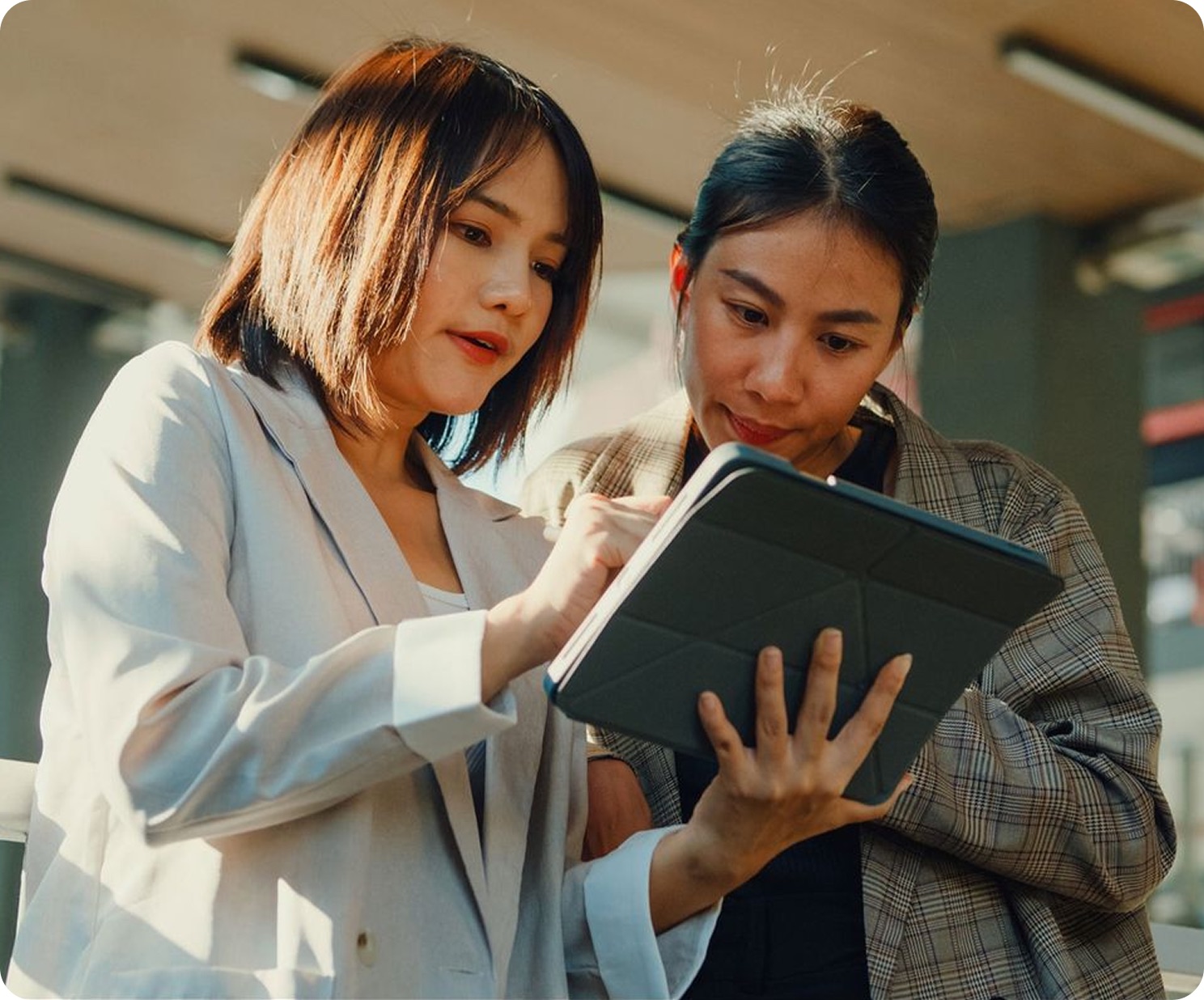 Two professionals reviewing their book together on a tablet