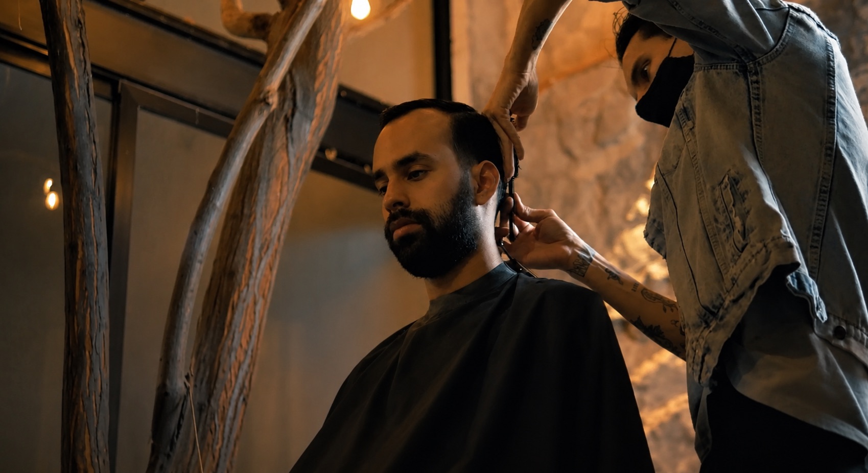A barber finishing a client's fade