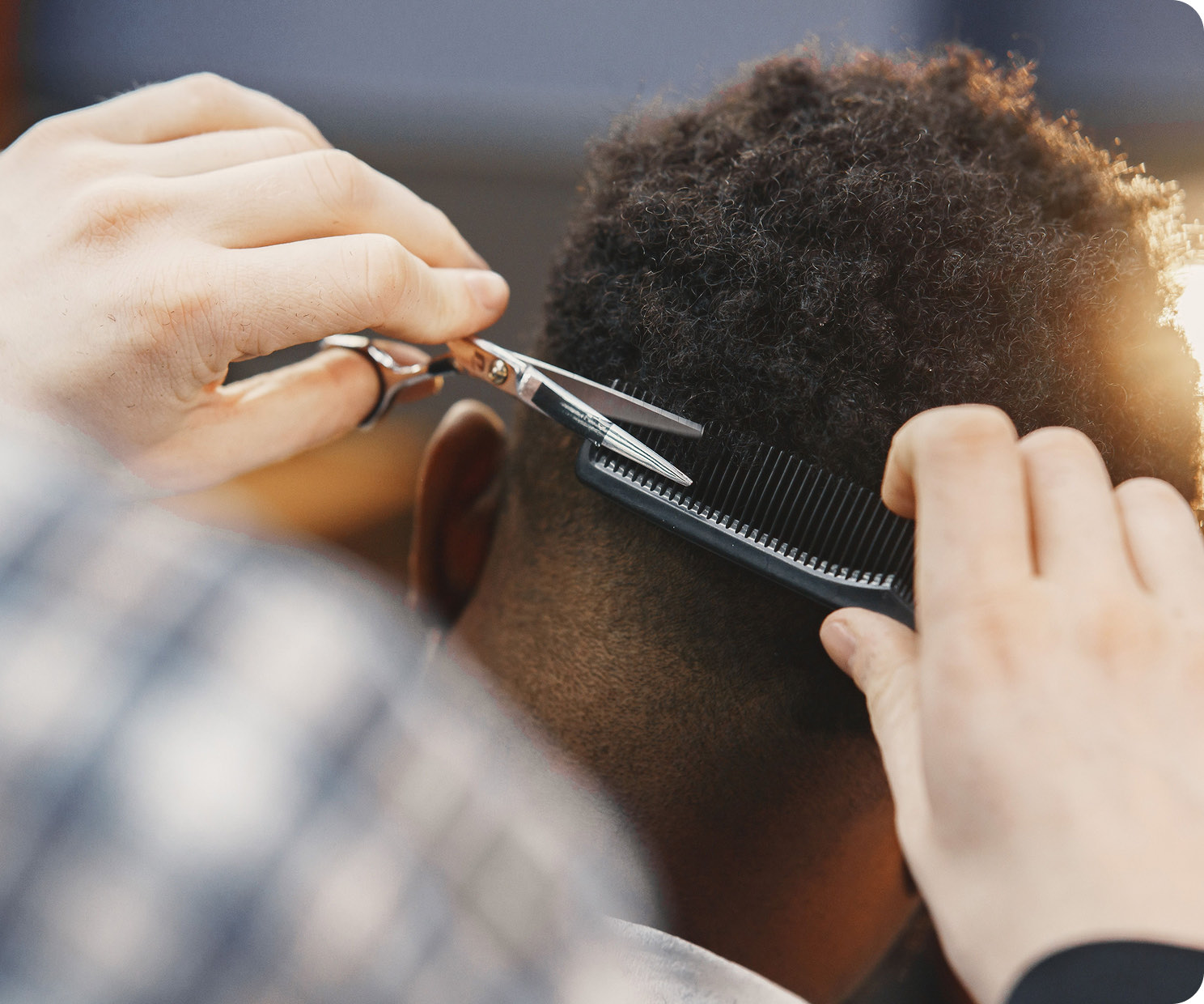 A barber cutting a client's hair with scissors