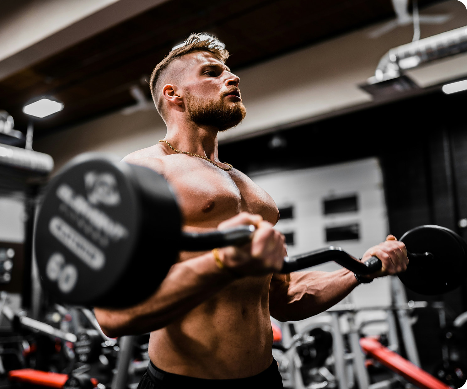 A trainer lifting a loaded barbell in a gym