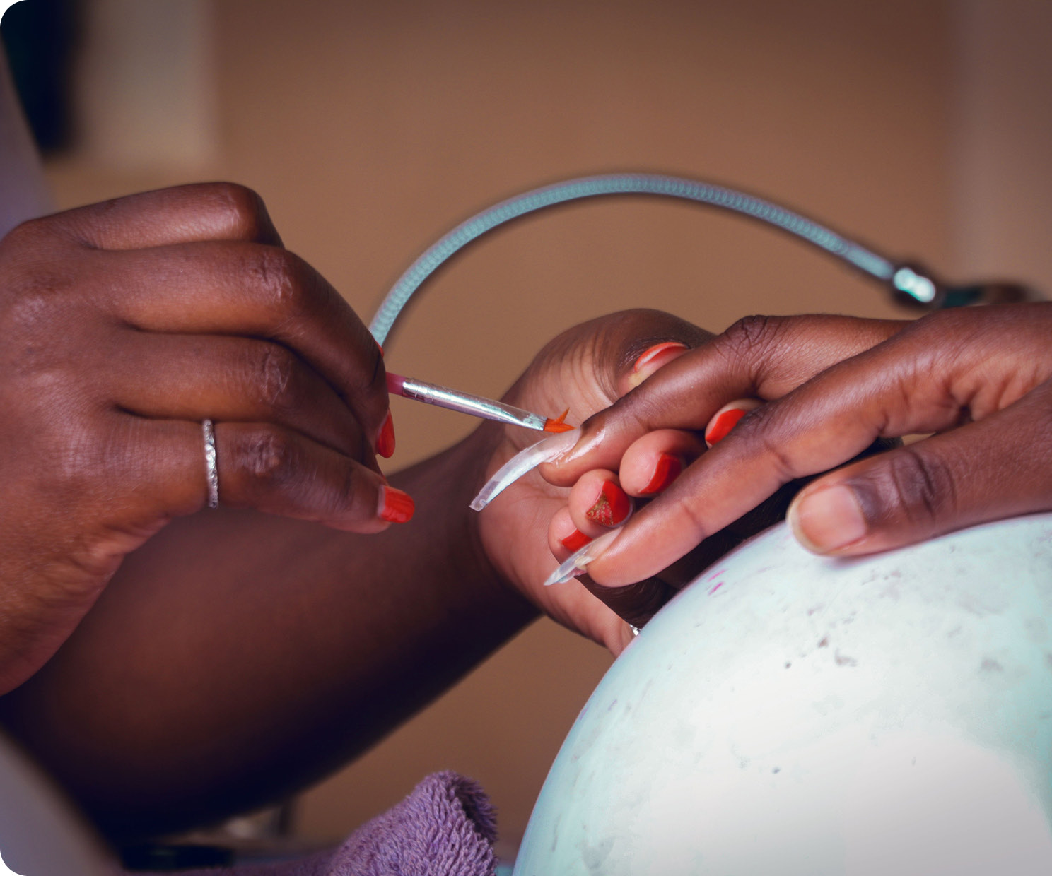 A nail tech filing a client's nails