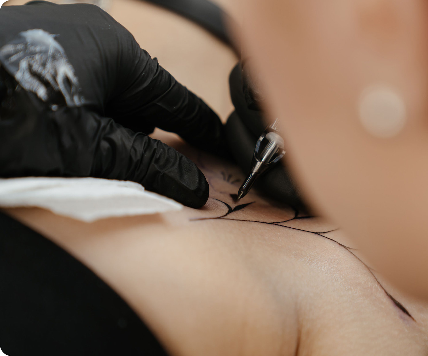 A tattoo artist working on a client