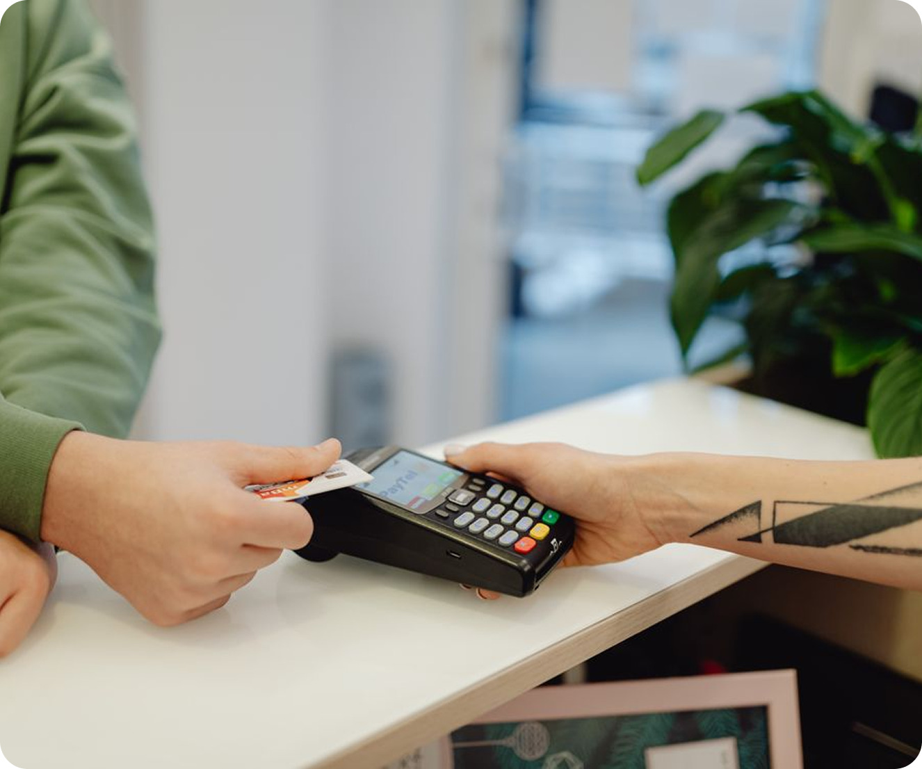 A client paying by card on a terminal held across the counter